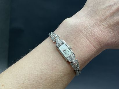 Montre de dame en or, pavage de petits diamants.
Art...