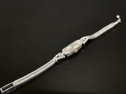 Montre de dame en or, pavage de petits diamants.
Art...