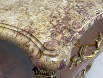 Commode galbée marquetée ouvrant à deux tiroirs.
Style...