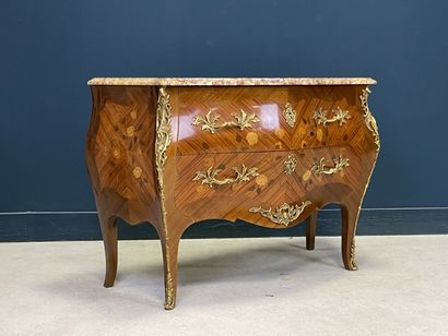 Commode galbée marquetée ouvrant à deux tiroirs.
Style...