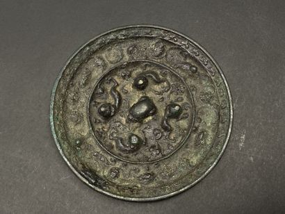 Petit miroir en bronze patiné à décor de...