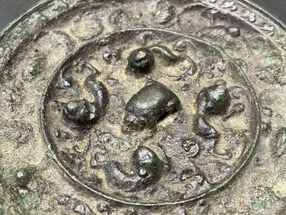 Petit miroir en bronze patiné à décor de...