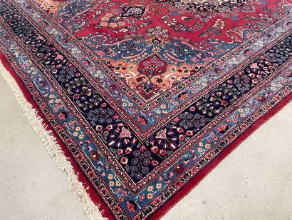 Grand tapis d'Orient en laine.Fond rouge...