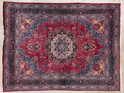 Grand tapis d'Orient en laine.Fond rouge...