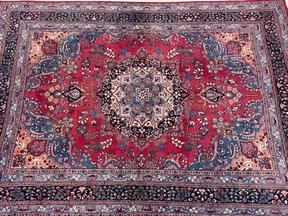 Grand tapis d'Orient en laine.Fond rouge...