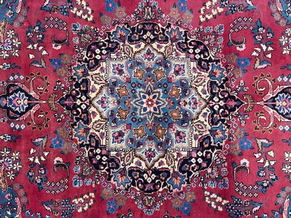 Grand tapis d'Orient en laine.Fond rouge...