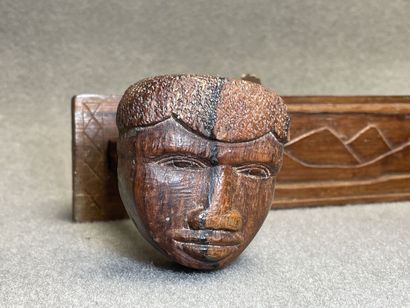 Patère en bois sculpté à décor de trois visages...