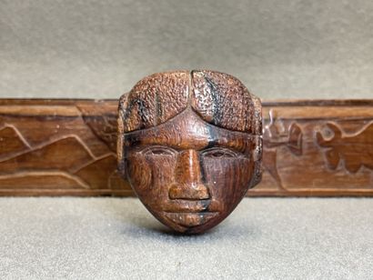 Patère en bois sculpté à décor de trois visages...
