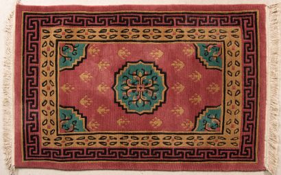 Tapis en laine à fond vieux rose à décor...