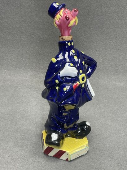 Flacon en faience figurant un gendarme et...
