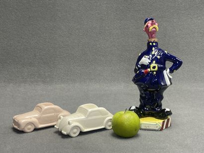 Flacon en faience figurant un gendarme et...