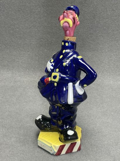 Flacon en faience figurant un gendarme et...
