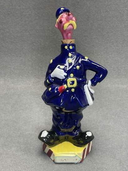Flacon en faience figurant un gendarme et...