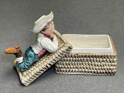 Boite en barbotine figurant un enfant allongé...