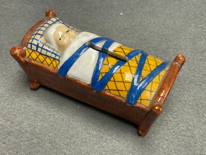 H. QUIMPER. 
Tirelire berceau en faience.
7...