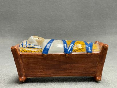 H. QUIMPER. 
Tirelire berceau en faience.
7...
