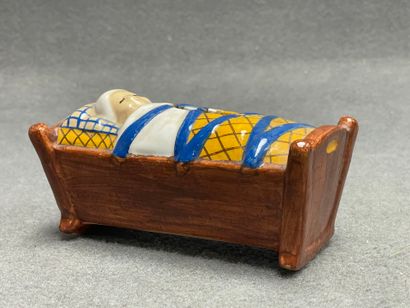 H. QUIMPER. 
Tirelire berceau en faience.
7...