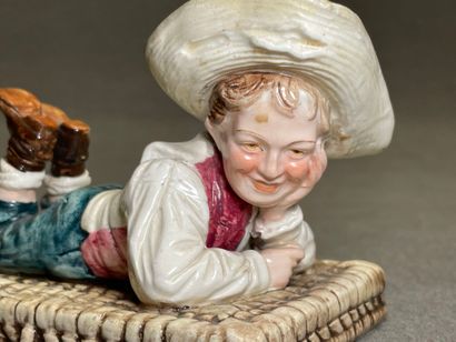 Boite en barbotine figurant un enfant allongé...