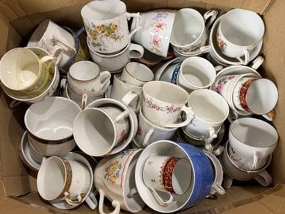 Carton de tasses dépareillées.