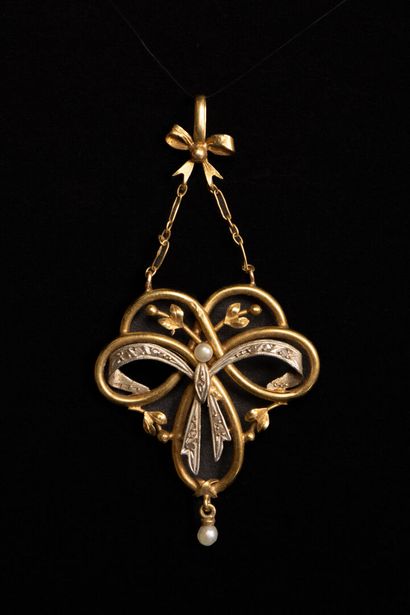 Gold pendant featuring a scroll supported...