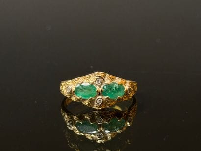 Gold ring set with two oval emeralds and...