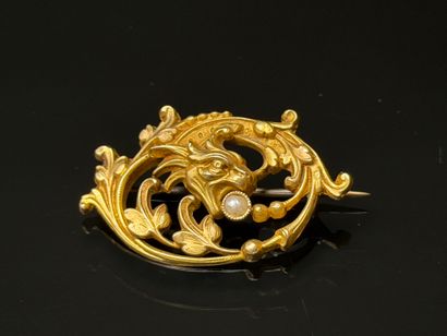 Gold brooch featuring a chimera head with...
