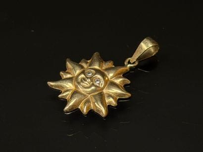 Gold sun pendant with small diamond eyes.
750°/00...