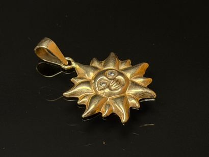 Gold sun pendant with small diamond eyes.
750°/00...
