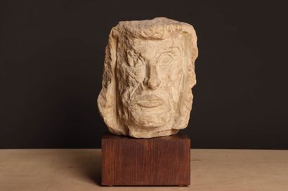 Tête en pierre sur socle bois. 
H. :27 cm....