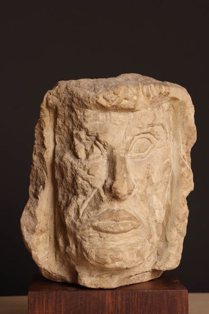 Tête en pierre sur socle bois. 
H. :27 cm....