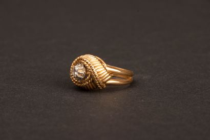 Twisted gold ring set with a diamond weighing...