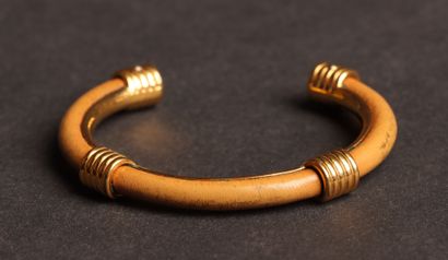 HERMÈS 
Open-ended bangle in gold-tone metal...