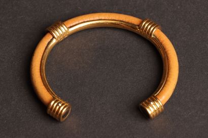 HERMÈS 
Open-ended bangle in gold-tone metal...