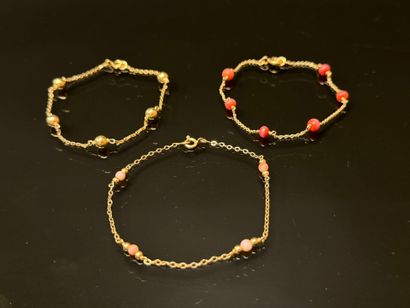 Set of three gold bracelets punctuated with...