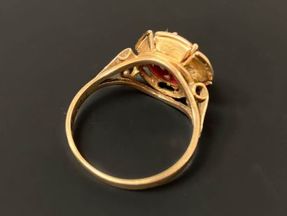 Gold ring set with a red stone.
750°/00 gold
TDD...