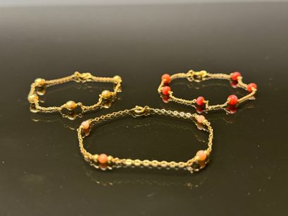 Set of three gold bracelets punctuated with...
