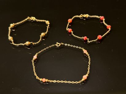 Set of three gold bracelets punctuated with...