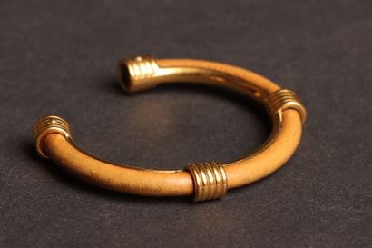 HERMÈS 
Open-ended bangle in gold-tone metal...