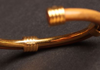 HERMÈS 
Open-ended bangle in gold-tone metal...