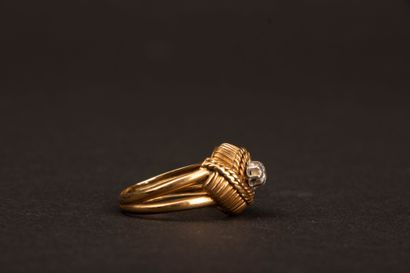 Twisted gold ring set with a diamond weighing...