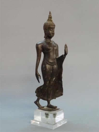 Bouddha marchant, vêtu d'une cape monastique...