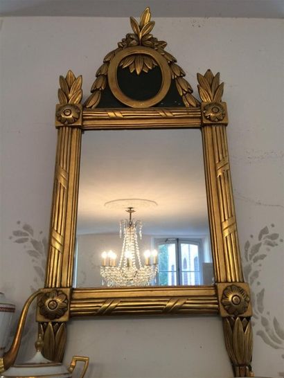 Miroir en bois et stuc doré à fronton médaillon.

Style...