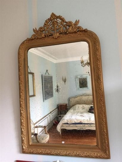 Miroir cadre doré à décor en fronton de dauphins.

125...