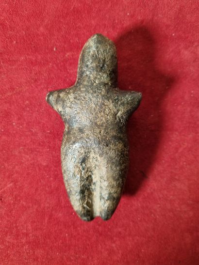 Stylized anthropomorphic votive statuette.

Black...