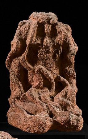 Headless figure kneeling with hands on thighs....