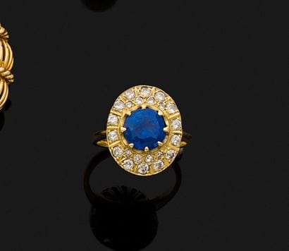 Bague en or sertie d’un saphir coussin, l’entourage...