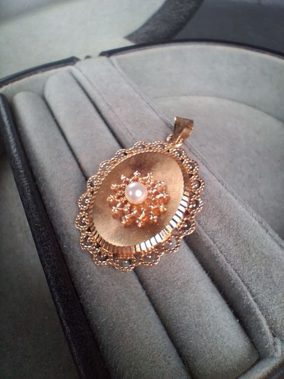 Pendentif ovale en or jaune (750/1000) centré...