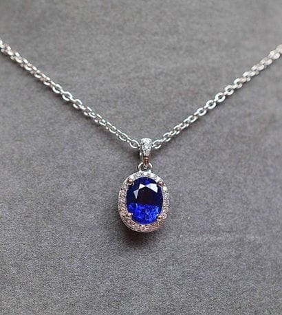 Pendentif or blanc soutenant un saphir ovale...