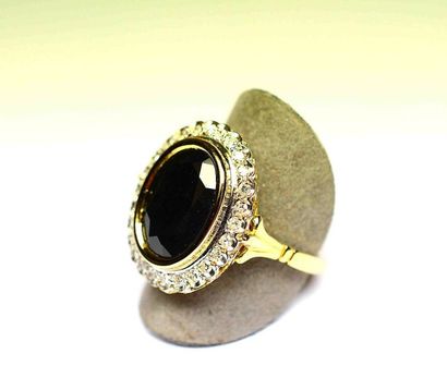 Bague bicolore centrée en clos d'un saphir...