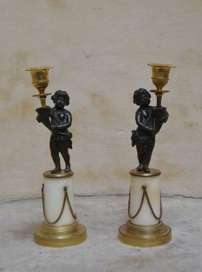 PAIRE de BOUGEOIRS en bronze patiné figurant...
